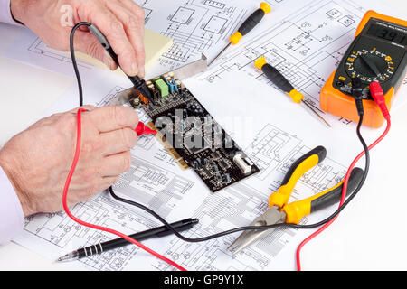 Electronics engineer testing a computer PCI card with a multi meter Stock Photo