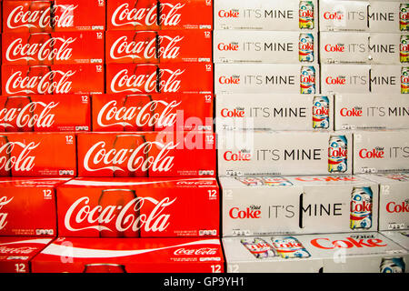 Cans of Coca-Cola cases stacked in a display at a grocery store. Stock Photo