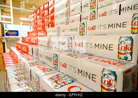 Cans of Coca-Cola cases stacked in a display at a grocery store. Stock Photo