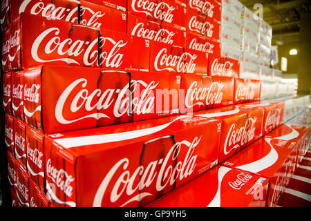 Cans of Coca-Cola cases stacked in a display at a grocery store. Stock Photo