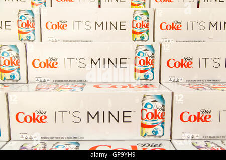 Cans of Coca-Cola cases stacked in a display at a grocery store. Stock Photo