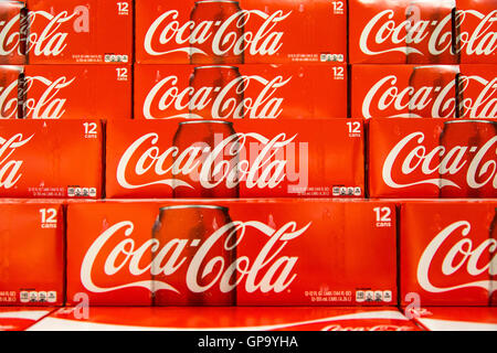 Cans of Coca-Cola cases stacked in a display at a grocery store. Stock Photo