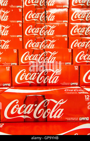 Cans of Coca-Cola cases stacked in a display at a grocery store. Stock Photo