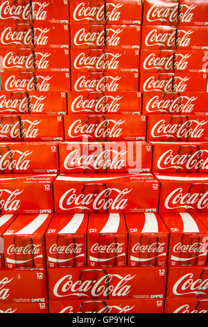 Cans of Coca-Cola cases stacked in a display at a grocery store. Stock Photo