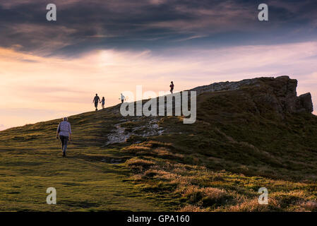 Sunset as holidaymakers enjoy a late evening walk on the summit of Porth Island in Newquay, Cornwall. Stock Photo
