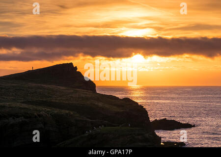 A spectacular sunset builds over Porth Island and Trevelgue Head in Newquay, Cornwall. Stock Photo