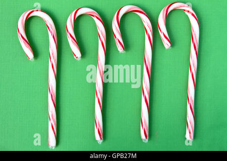Four candy canes on green background. Stock Photo