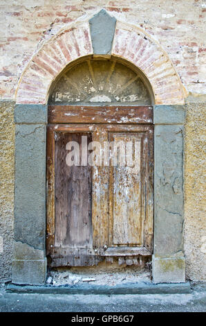 Ancient wooden door with hinges and knocker wrought iron handicraft Stock Photo