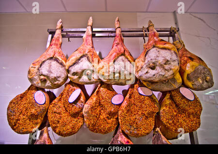 hams hanging just out of the period of the traditional seasoning with spices, salt, pepper and hot pepper and ready for sale Stock Photo