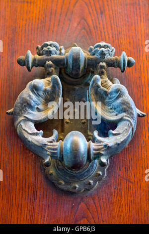 old door with knocker with winged demons with his mouth open Stock Photo