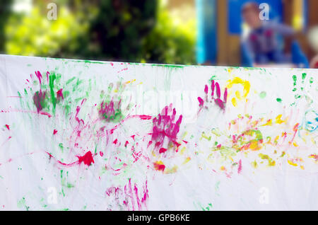 children playing making colorful designs with hands dipped in colored dye Stock Photo