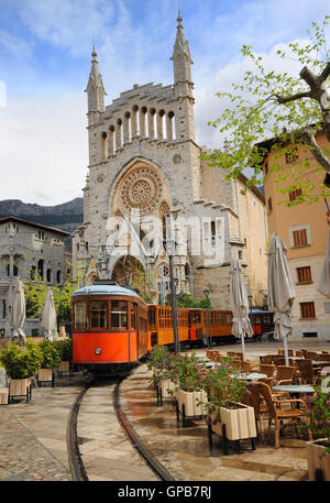 Old tram in the downtown of Soller in front of medieval gothic cathedral with huge rose window, Mallorca, Spain Stock Photo