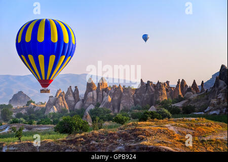 Cappadocia hot air balloon flying over bizarre rock landscape in Turkey Stock Photo