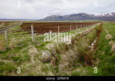 drainage ditches dug beside fields in Iceland Stock Photo