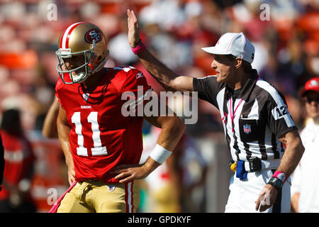 Oct 30, 2011; San Francisco, CA, USA; NFL referee Bill Leavy (right) pats San Francisco 49ers quarterback Alex Smith (11) on the helmet before the game against the Cleveland Browns at Candlestick Park. Stock Photo