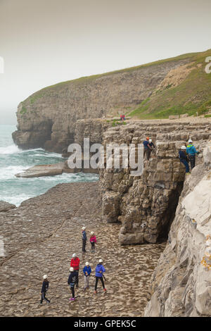 School children heading climbing on the Cliffs near Dancing ledge Dorset. Stock Photo