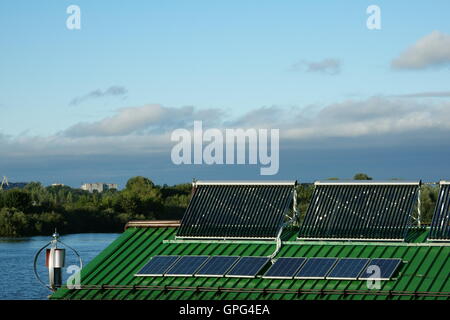 Solar water heater and battery. Wind turbine on the roof Stock Photo