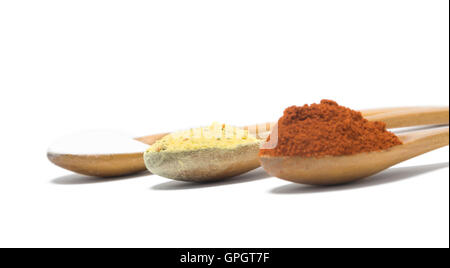 three common spices in wooden spoons isolated on white background, selective focus. Stock Photo