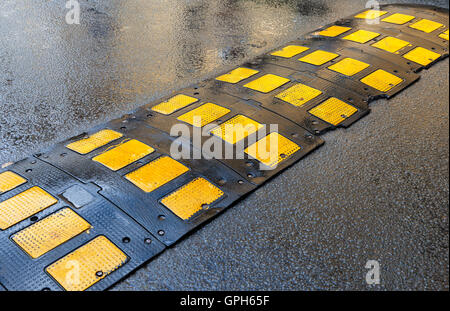 Traffic safety speed bump on an asphalt road Stock Photo