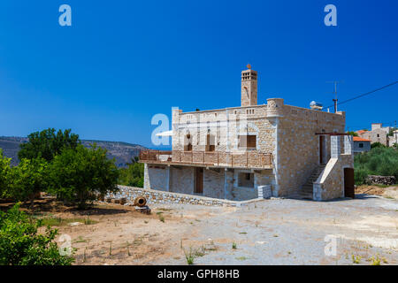 Traditional style built house in Itilo village against a blue sky and clouds in Mani, Laconia, Greece Stock Photo