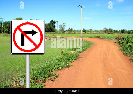 don't turn right sign with a left curved soil road Stock Photo