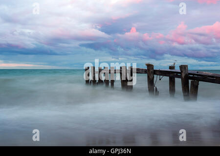 A weathered and broken pier located near Burlington, Ontario taken at sunset and twilight. Stock Photo