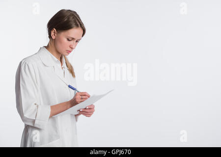 Cheerful medical doctor woman taking notes. Isolated on white Stock Photo