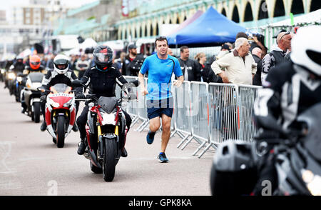 Brighton UK 4th September 2016 - A runner joins the thousands of bikers and rockers from around the world taking part in the annual Ace Cafe Reunion Brighton Burn Up event held on the seafront today . Motorcyclists and rockers converge on Madeira Drive on the seafront every year to celebrate the famous Ace Cafe in London with bands playing and hundreds of stalls selling memorabilia   Credit:  Simon Dack/Alamy Live News Stock Photo