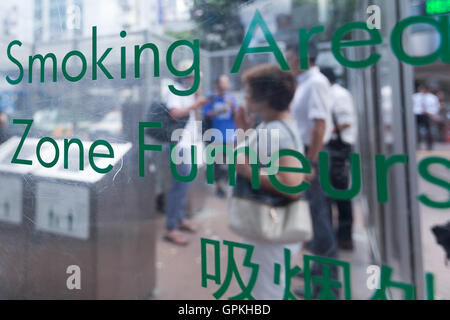 People smoke in a designated smoking area outside Shibuya station on September 5, 2016, Tokyo, Japan. The Japanese Health, Labor and Welfare Ministry called on the government to prohibit smoking in public spaces indoors such as inside stations, public buildings and restaurants, to combat passive smoking. Currently Japan still has many smoking areas inside restaurants with some not even segregated. The Ministry aims to ban smoking indoors before the Tokyo 2020 Olympic Games. © Rodrigo Reyes Marin/AFLO/Alamy Live News Stock Photo