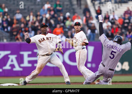 June 1, 2010; San Francisco, CA, USA;  Colorado Rockies center fielder Carlos Gonzalez (right) breaks up a double play as San Francisco Giants shortstop Juan Uribe (5) throws to first base during the first inning at AT&T Park. Stock Photo