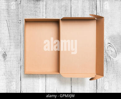 Open cardboard box top view on wooden background Stock Photo