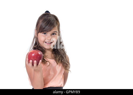 Smiling attractive little girl is offering a red apple. Everything is on a white background. Stock Photo