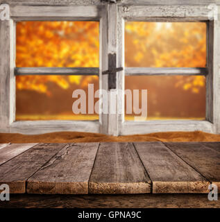 Autumn still life with empty wooden planks planks, placed in front of wooden window. Cozy home interior. Stock Photo