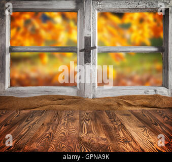 Autumn still life with empty wooden planks planks, placed in front of wooden window. Cozy home interior. Stock Photo