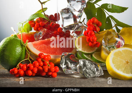 Mountain ash berries on branches with leaves and the cut citrus fruits  ice pieces Stock Photo