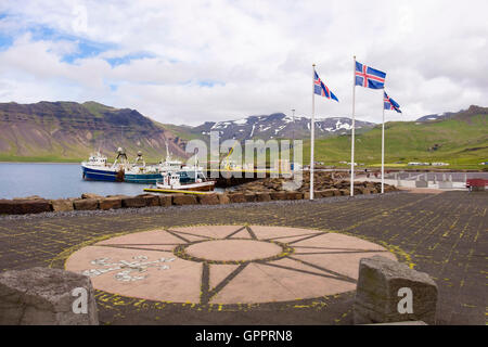 Icelandic flags flying on the quay with fishing boats moored in the harbour. Grundarfjordur, Snaefellsnes Peninsula, Iceland Stock Photo