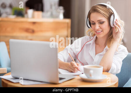 Cute young woman writing something down Stock Photo