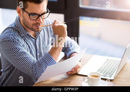 Thoughtful man sitting at the table Stock Photo