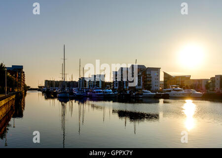 An early morning shot of Portishead Quays Marina with boats and yachts moored and reflected in the still marina water Stock Photo