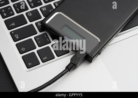 External hard disk over laptop keyboard Stock Photo