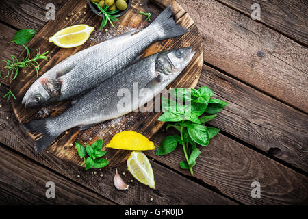 raw seabass fish on wooden background top view Stock Photo