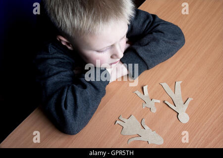 Confused child with broken paper family, family problems, divorce, custody battle, suffer concept Stock Photo