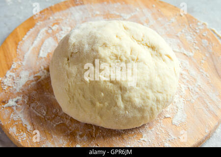 Raw homemade pizza dough on cutting board Stock Photo