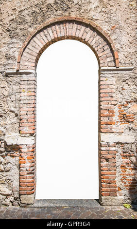 Old wooden door with upper railing and brick archway suitable as a frame. Stock Photo