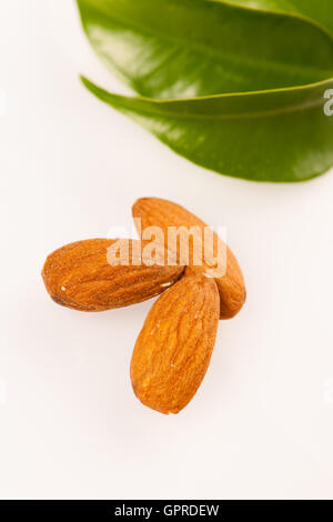 Three almond kernels, healthy snack isolated on white background. Stock Photo