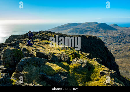 A walker on the summit ridge of Trollabhal in the Rum Cuillin hills, Isle of Rum, Scotland, UK. Stock Photo