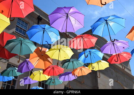 Multi-colored umbrellas against blue sky over a street Stock Photo