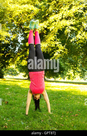 fitness girl doing  a handstand in the park Stock Photo