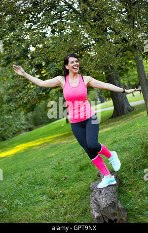 fitness girl having fun balancing on a log Stock Photo