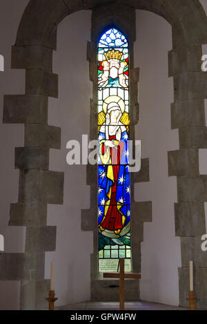 A narrow stained glass window in the church of St Mary and St Peter, Wilmington, East Sussex, UK Stock Photo